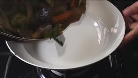 primer plano de deliciosas verduras asiáticas que se cocinan a fuego alto y se sirven en un plato