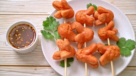 Brocheta de salchicha frita con salsa para mojar