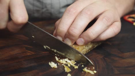 slicing brown sugar with kitchen knife on wooden cut board