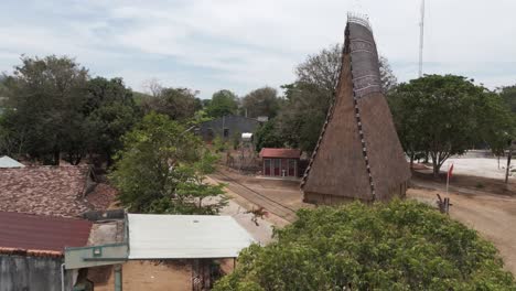 drone footage of a traditional bahnar house near kon tum in central highland vietnam. easy to recognize with the tall wooden roof