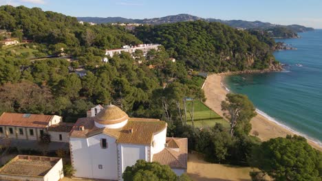 aerial image with drone of lloret de mar virgin beach with green vegetation in mediterranean church overlooking the sea in the mediterranean santa cristina lloret de mar spain europe