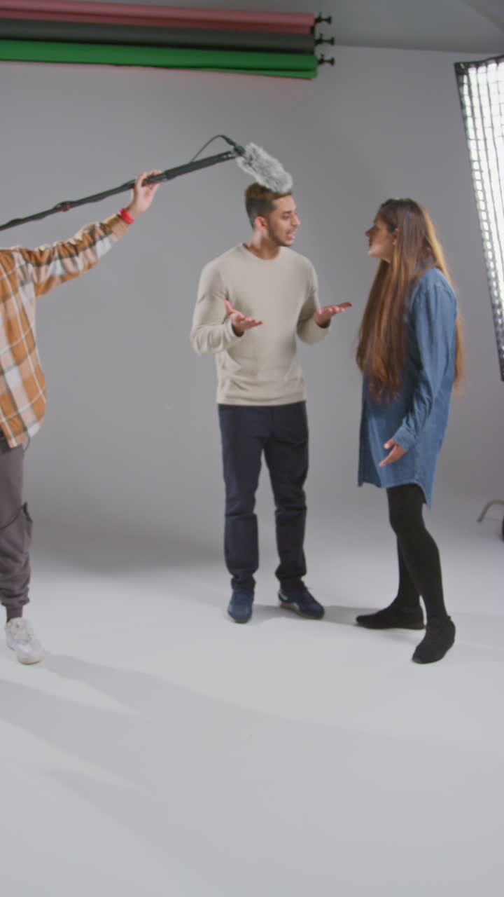 Vertical Video Of Frustrated Female Film Director Shooting Movie Or Video Scene In Studio As Sound Recordist Drops Microphone Into Shot