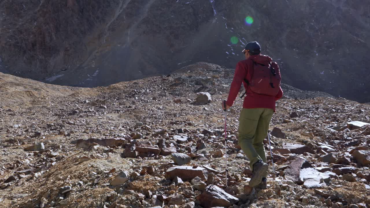 Hiker walking over challenging terrain in the Andes Mountains at high elevation. Slow motion, 4k
