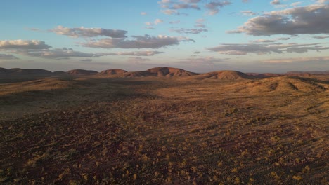 beautiful landscape of australian desert with rocky mounts in background at sunset, karijini area in western australia