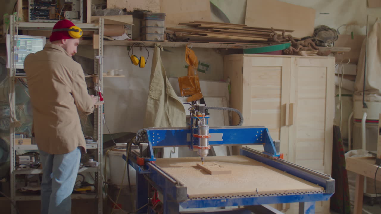 Man Operating Woodworking CNC Machine with Computer
