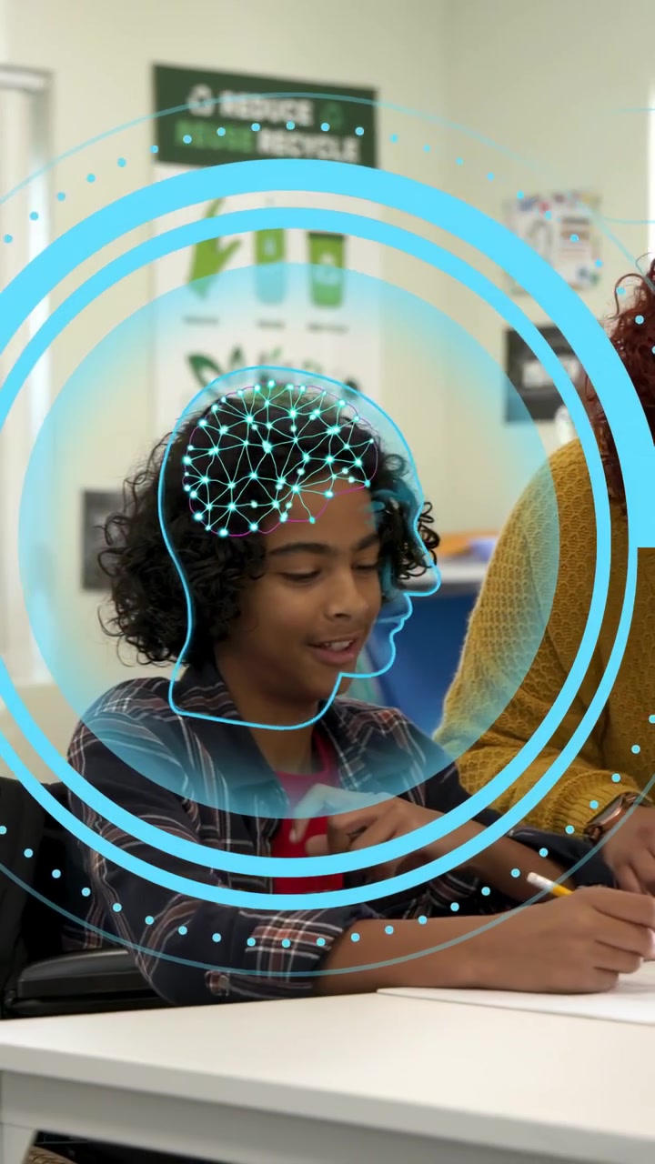Vertical video: Girl writing in class teacher leaning guiding pencil grip learning under blue HUD