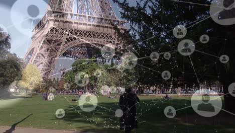 animación de perfiles que se conectan con líneas sobre el hombre hablando por teléfono contra la torre eiffel en el parque