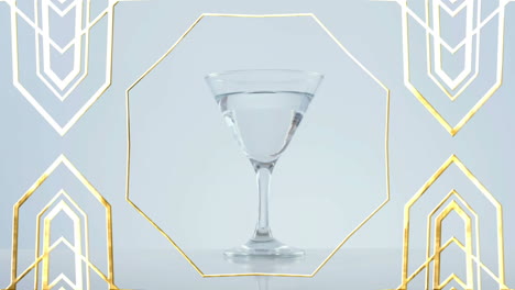 golden frame design pattern over olives falling into cocktail glass against grey background