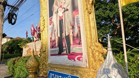 yellow flags waving beside a framed royal image