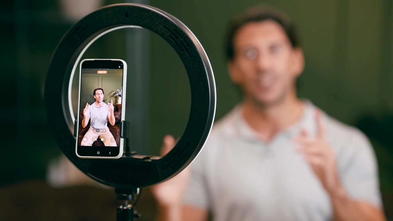 Man Recording Video Content with Smartphone and Ring Light