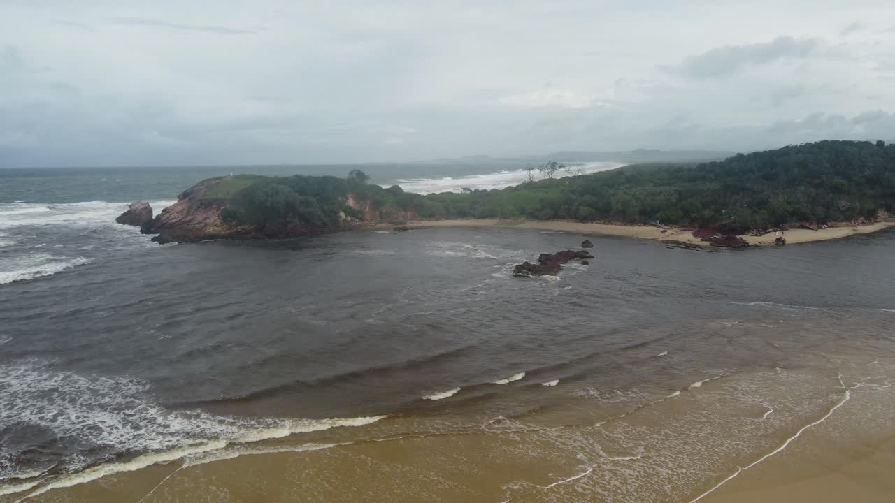 drone volando hacia la playa de roca roja y la península en australia