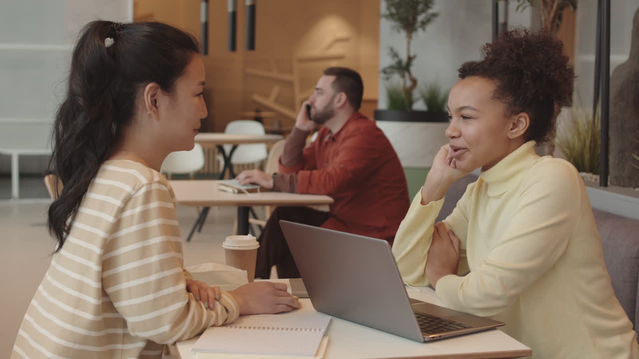 Diverse Girlfriends Chatting at Cafe Table