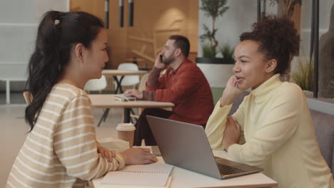 diverse girlfriends chatting at cafe table