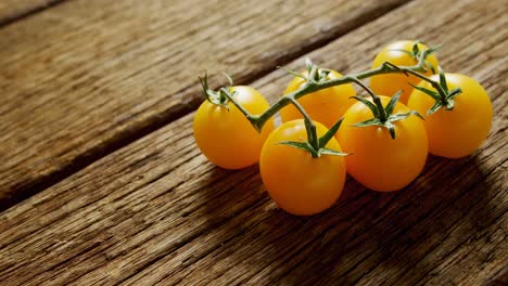 tomates de cereza amarillos con tallo en suelo de madera 4k 4k