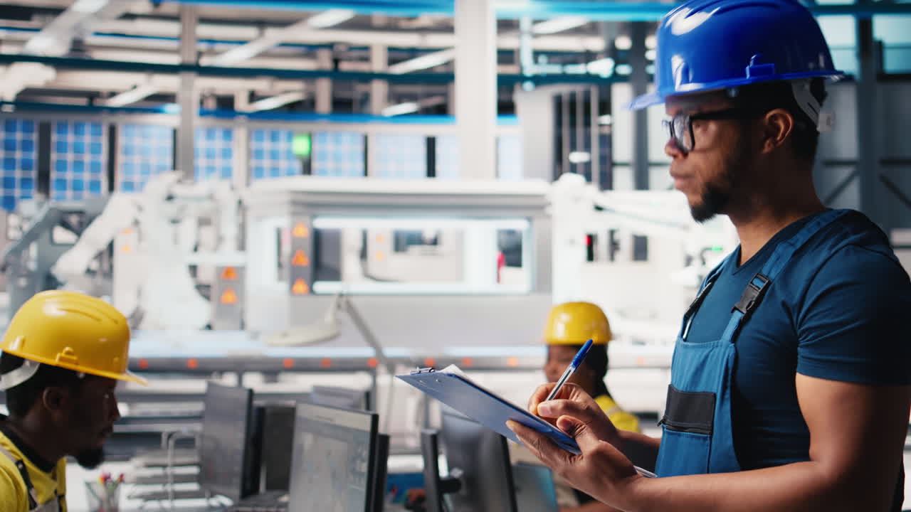 Vertical Video Black photovoltaics factory technician looking over paperwork documents