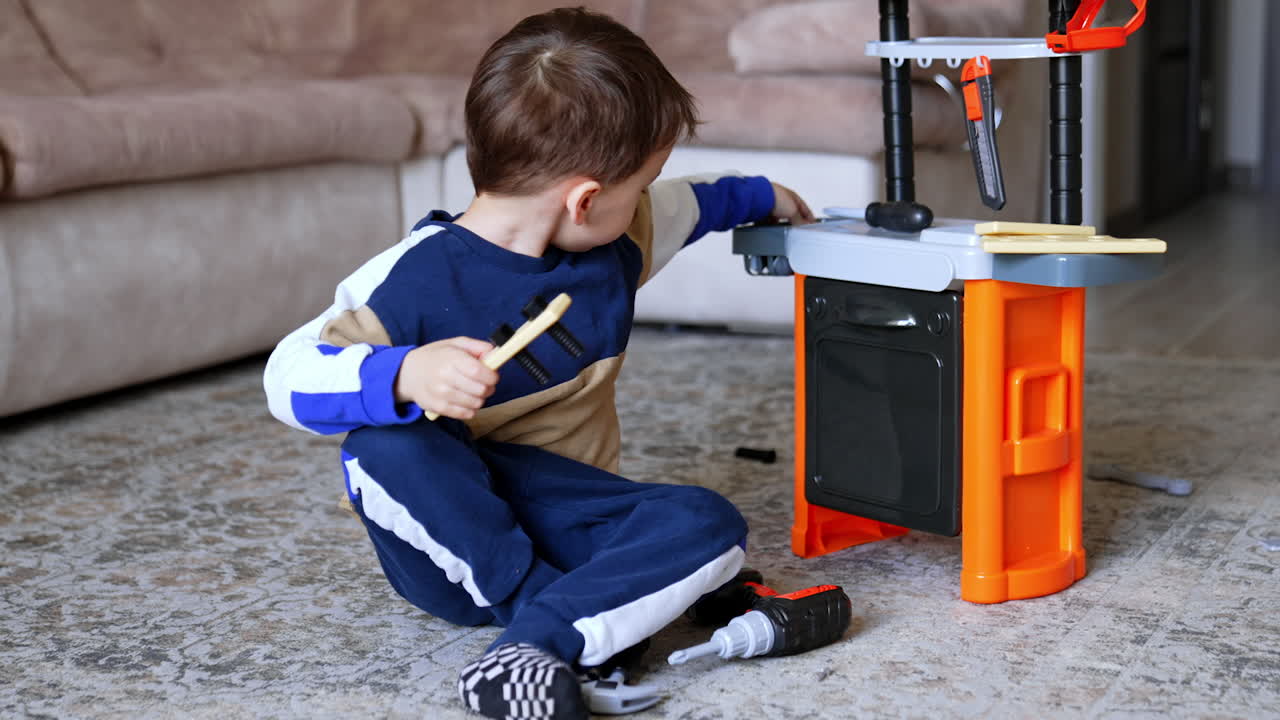 Child playing with toy tools indoors. A young child explores a toy toolset on a carpeted floor in a cozy living room, engaging in imaginative play