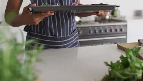 mid section of african american woman preparing dinner in kitchen