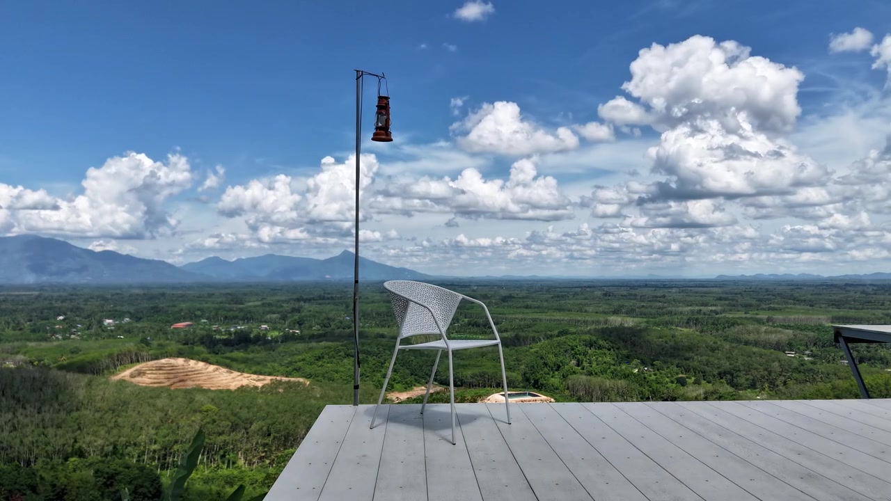 mesmerizing daytime time-lapse capturing rolling white fluffy clouds rolling over a vast, expansive green plain, open valley and distant mountains