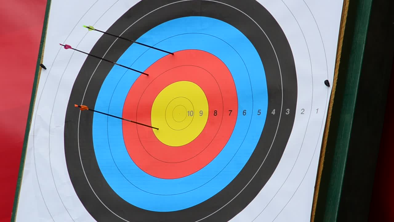 Arrow Strikes Colorful Archery Target with Existing Arrows