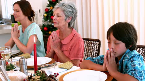 Extended-family-saying-grace-before-christmas-dinner