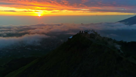 majestic aerial footage of mount batur in bali during sunrise. glowing volcanic peaks, morning mist, and golden skies create a stunning scene—ideal for nature, travel, and adventure content
