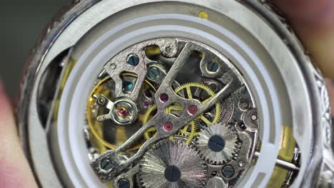 old pocket watch mechanism working, close up view