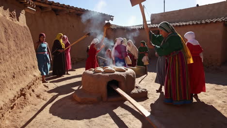 women baking bread in a traditional clay oven