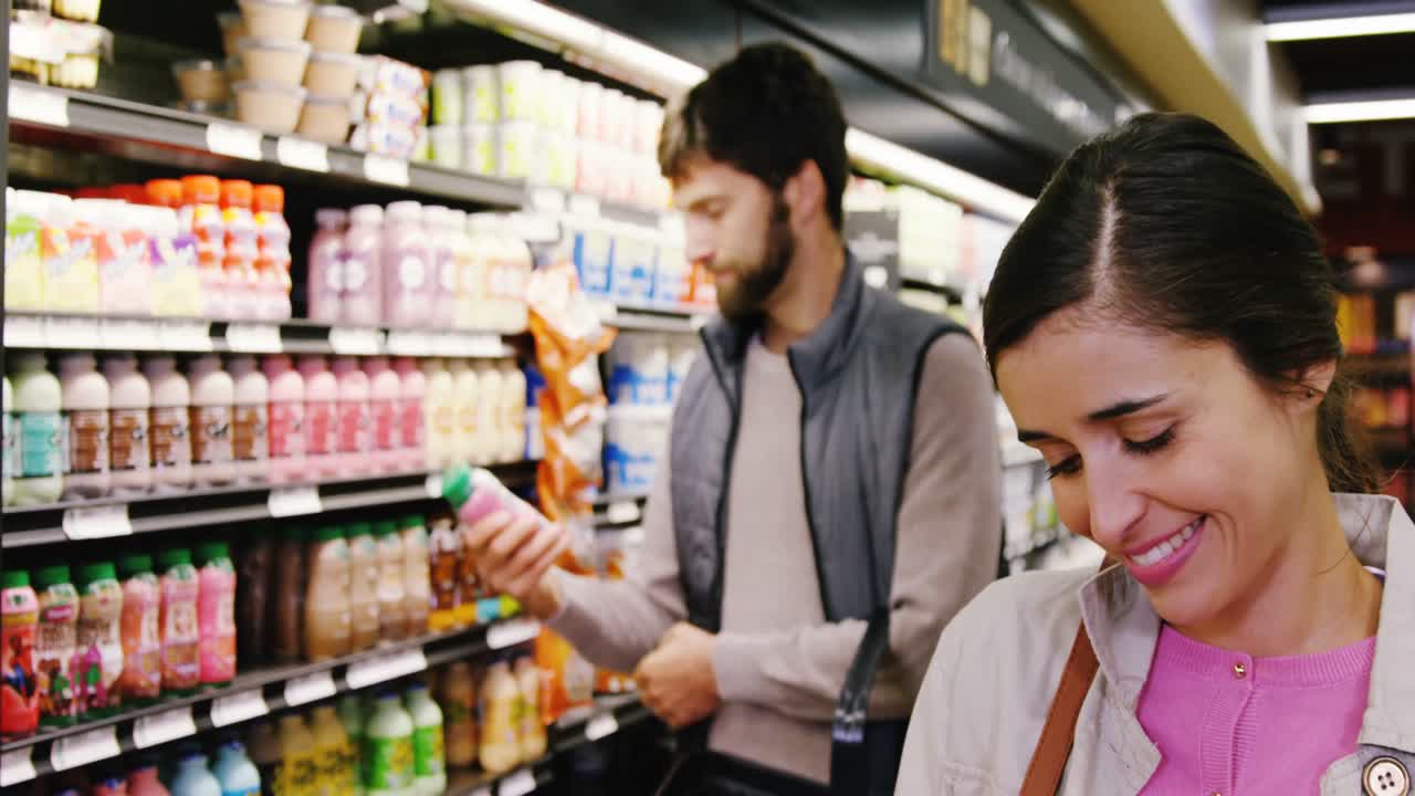 Mulher comprando produto lácteo na seção de laticínios