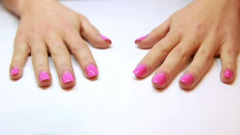 las manos muestran una manicura rosa fresca.