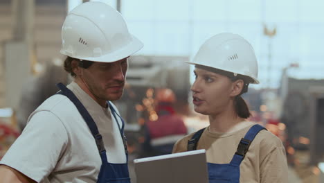 factory technicians reviewing and discussing information on digital tablet