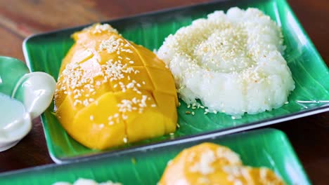 pouring coconut milk over mango sticky rice