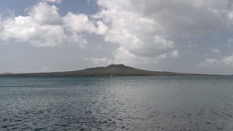 Toma-Estática-De-Nubes-Que-Se-Mueven-Rápidamente-Sobre-El-Impresionante-Volcán-Rangitoto-Frente-A-La-Costa-Este-De-Auckland