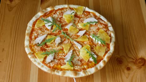 pizza with pineapple and chicken spinning in a circle. fast food. view from above