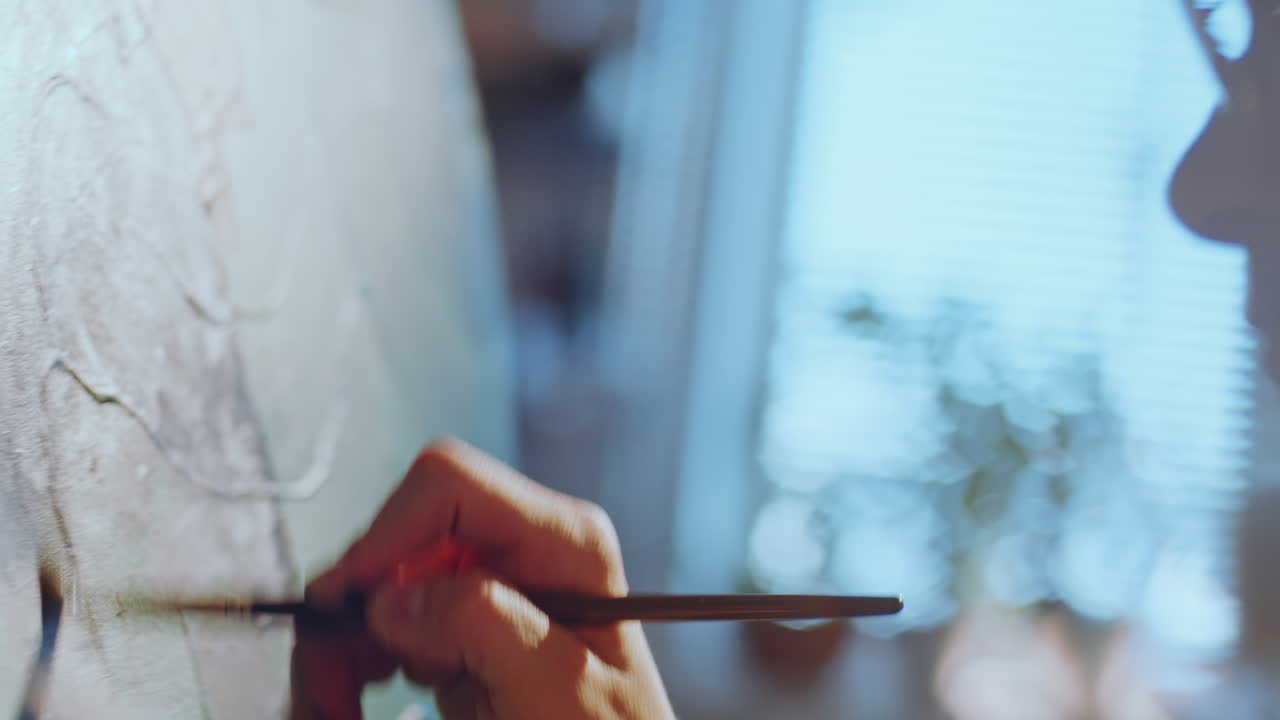 텍스처 된 캔버스에 브러쉬를 사용하여 그림을 그리는 예술가의 클로즈업