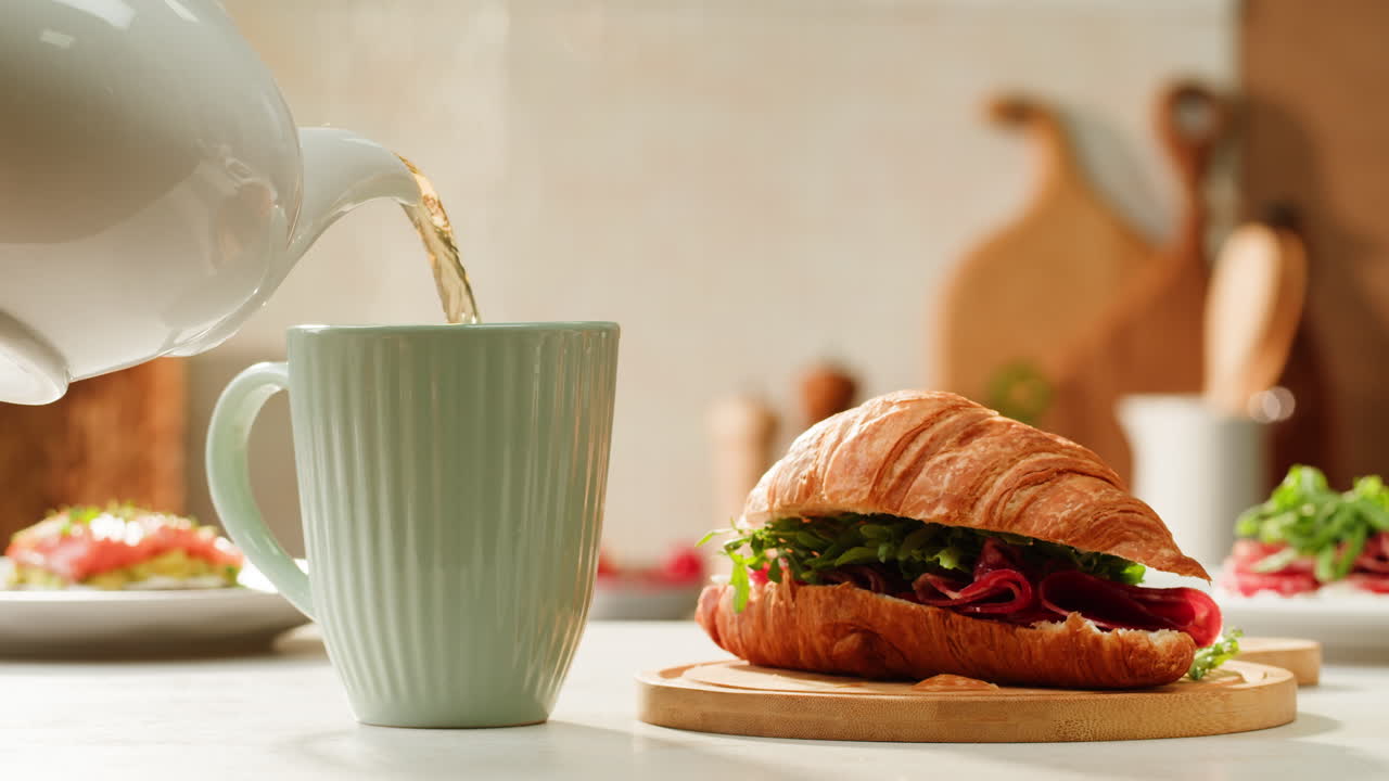 Breakfast scene with tea and croissant sandwich