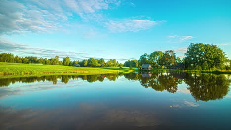 Ein-Sonnenaufgang-Mit-Vorbeiziehenden-Wolken-Am-Blauen-Himmel-über-Einem-Großen-See