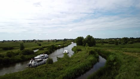 aerial drone video of the a couple of boats along the rural river yare on the norfolk broads