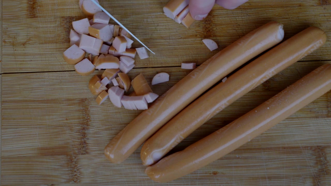 Preparazione per la colazione, tagliare le salsicce a cubetti piccoli