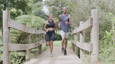 couple running across a wooden bridge