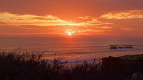 breathtaking sunset sky over the atlantic ocean with foamy waves in algarve, portugal