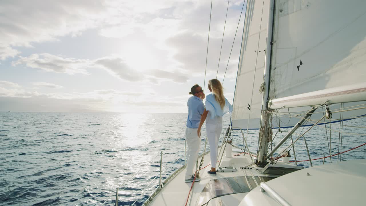 una pareja navegando hacia la puesta de sol.