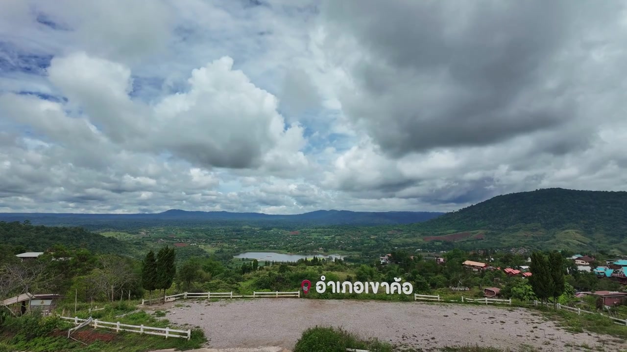 Magnifique timelapse panoramique de nuages blancs et gris se déplaçant rapidement à travers un vaste ciel au-dessus d'une vallée verdoyante à Phetchabun. Comprend des collines ondulantes, un lac lointain et un panneau de point de vue en Thaïlande