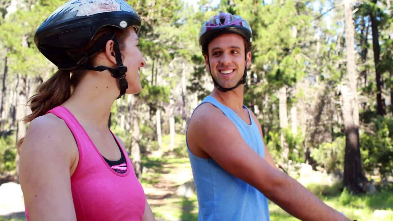 pareja en bicicleta a través de un bosque