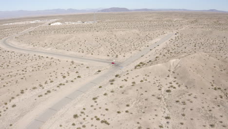 vista aérea siguiendo un coche rojo conduciendo por el desierto