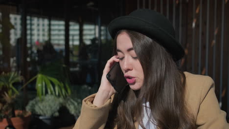 woman talking on phone in a cafe