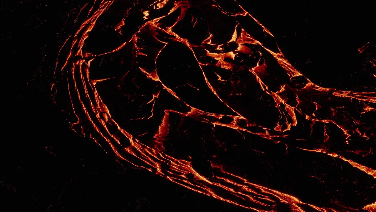 Sopra un fiume fluido di lava arancione di notte presso il vulcano Fagradalsfjall in Islanda.