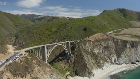 aerial view of bixby creek bridge with tourists' cars in parking lot