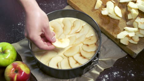 Preparing-for-baking-apple-pie.-Cook-puts-apple-slices-in-baking-dish