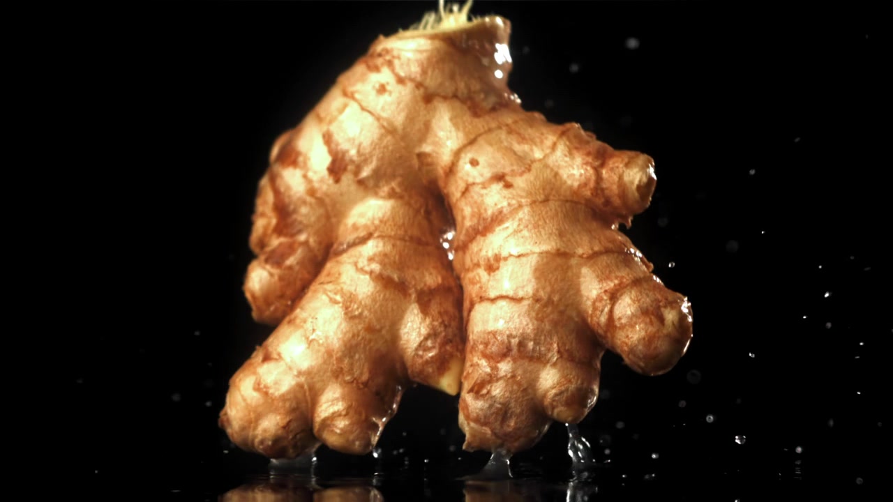 Fresh Ginger Root Falling in Slow Motion with Water Splashes
