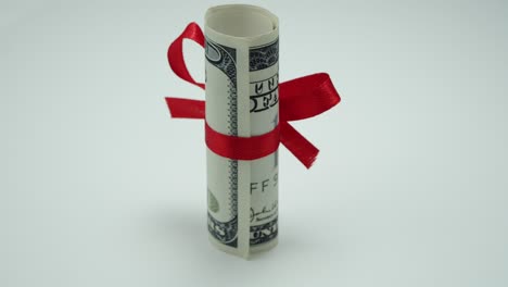 tube of dollar with red ribbon